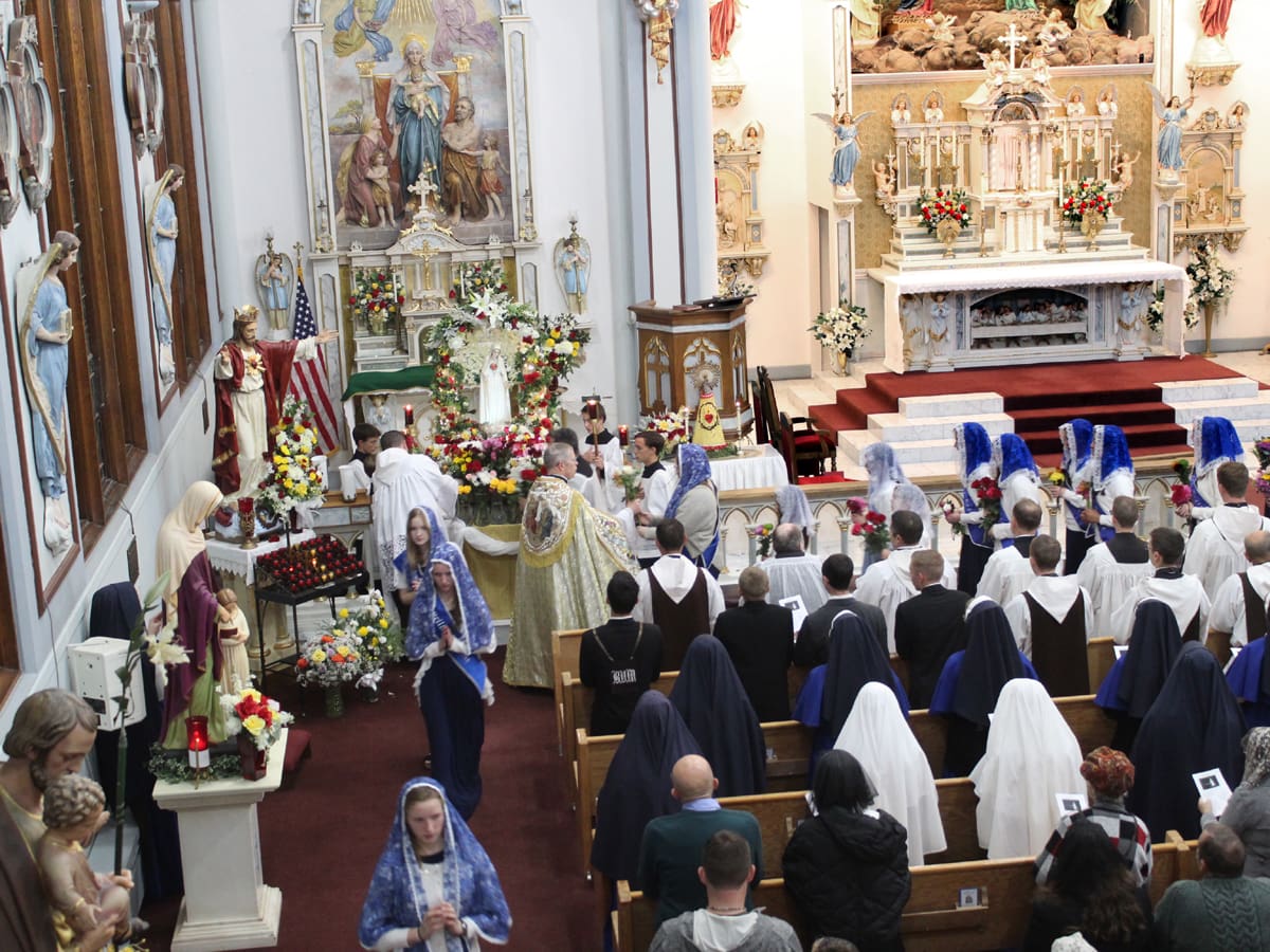 Sodalists bring flowers to present to Our Lady.