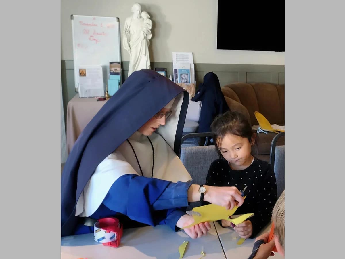 Sr. Sophia Marie helps a young student with a catechism project during a weekend mission in Boise, Idaho.
