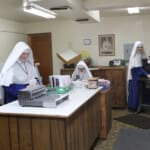 In addition to formation classes and farm work at the Novitiate, the novices help at Mary Immaculate Queen Center in the bindery and order filling rooms. Sister novices working in the bindery.