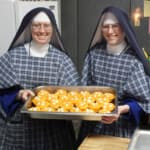 A special treat. Sr. Mary Cabrini and Sr. Sophia Marie display the orange yams they prepared for Christmas dinner. Sisters show their yam-stuffed oranges