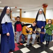 Rev. Mother Mary Agnes visits the students of St. Theresa’s School (Oakland, Maine), one of whom is demonstrating his first quarter project of learning the guitar. Rev. Mother visits St. Theresa's School