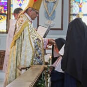 Sr. Dymphna Marie receives the blue veil and crown of roses as she makes her first profession of vows.