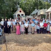 Parishioners and catechism campers gather by the new playground at St. Theresa’s in Oakland, Maine.
