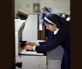 Sr. Maria looks very focused as she sets up a job on the electric cutter.