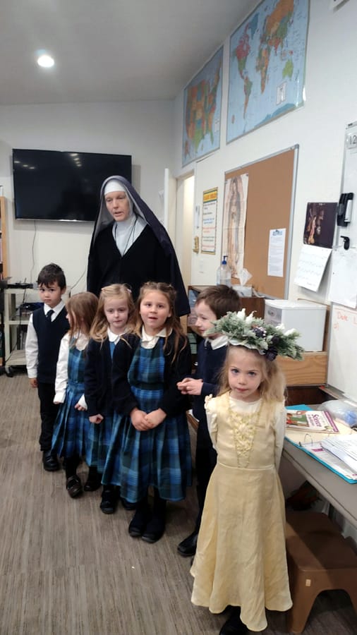 St. Lucy wearing the traditional wreath with candles visits Sr. Mary Josephine’s kindergarten class at Mary Immaculate Queen school on her feast day.