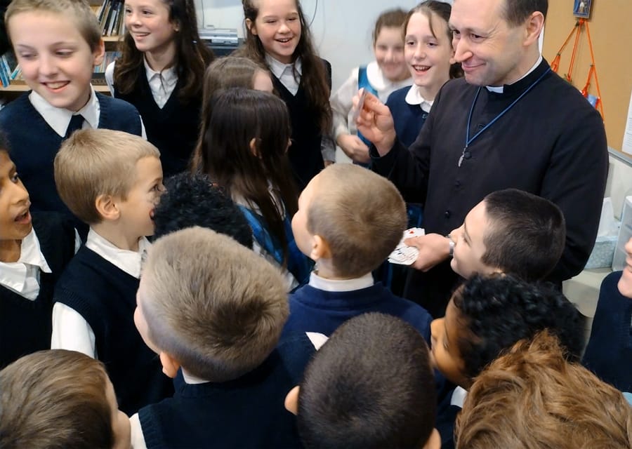 Fr. Gabriel Lavery, CMRI, entertains the students of Mary Immaculate Queen School with a card trick.