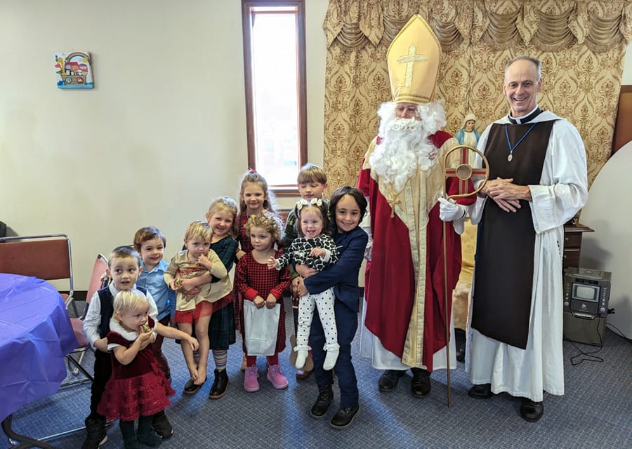 Fr. Gregory Drahman is happy to see the children of Sacred Heart Church (Akron, Ohio) welcome St. Nicholas for his annual visit.