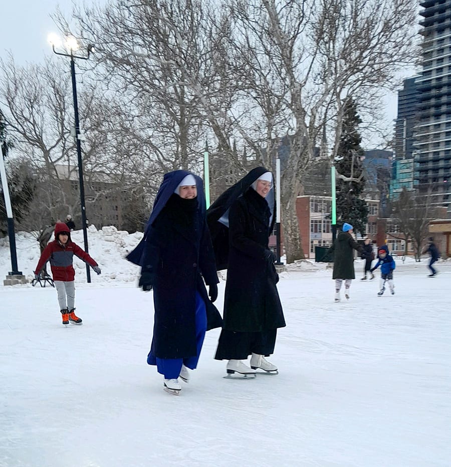 Black and blue nuns. Sr. Marie Bernadette, CMD, and Sr. Maria Magdalena, CMRI. enjoy themselves while supervising their students at a joint ice-skating event.