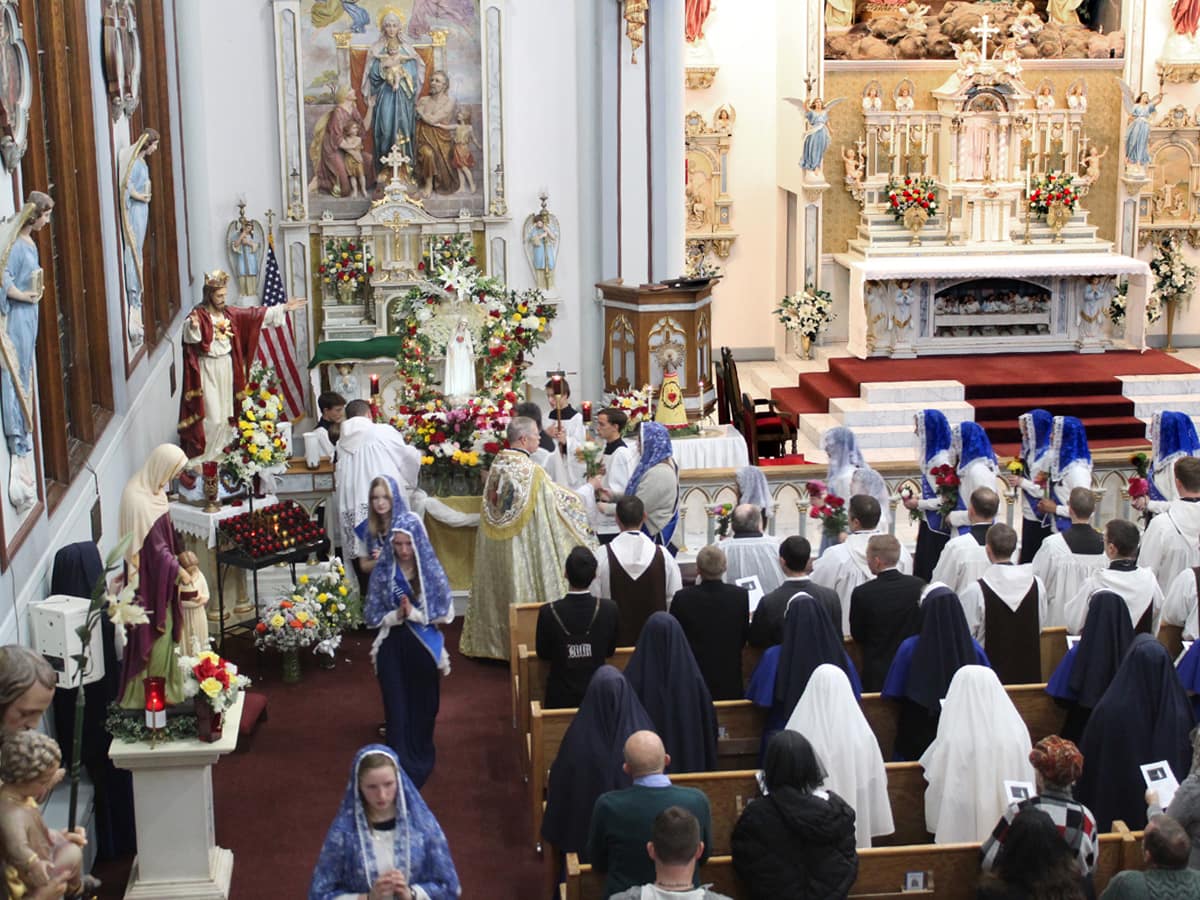 Sodalists bring flowers to present to Our Lady.
