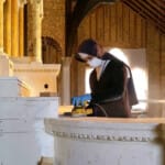 Armed with a dust mask and electric sander, Sister Mary Cecilia works on the altar at Saint Joseph’s in Olathe, Colorado. The Sisters
have been doing detail work in the new church Sanding an altar in the church being built in Olathe, CO