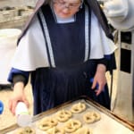 Sr. Marie Vianney sprinkles salt on the pretzels before putting them in the oven.