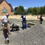 Sr. Maria Regina helps shovels gravel alongside parents and students in a work party to improve the school grounds of Holy Guardian Angels School in Olathe, Colorado.