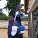 In Tacoma, Sr. Mary Cabrini and Sr. Mary Angela paint the garden house.