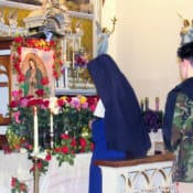 Sisters and parishioners bring roses to the shrine of Our Lady of Guadalupe during the Rosary on her feast.