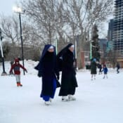 Black and blue nuns. Sr. Marie Bernadette, CMD, and Sr. Maria Magdalena, CMRI. enjoy themselves while supervising their students at a joint ice-skating event.