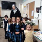 St. Lucy wearing the traditional wreath with candles visits Sr. Mary Josephine’s kindergarten class at Mary Immaculate Queen school on her feast day.