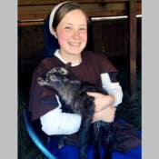 Sister holds a newly-born lamb. The Novitiate farm was nursery to thirteen lambs this spring, more than doubling the size of the flock within a few days.
